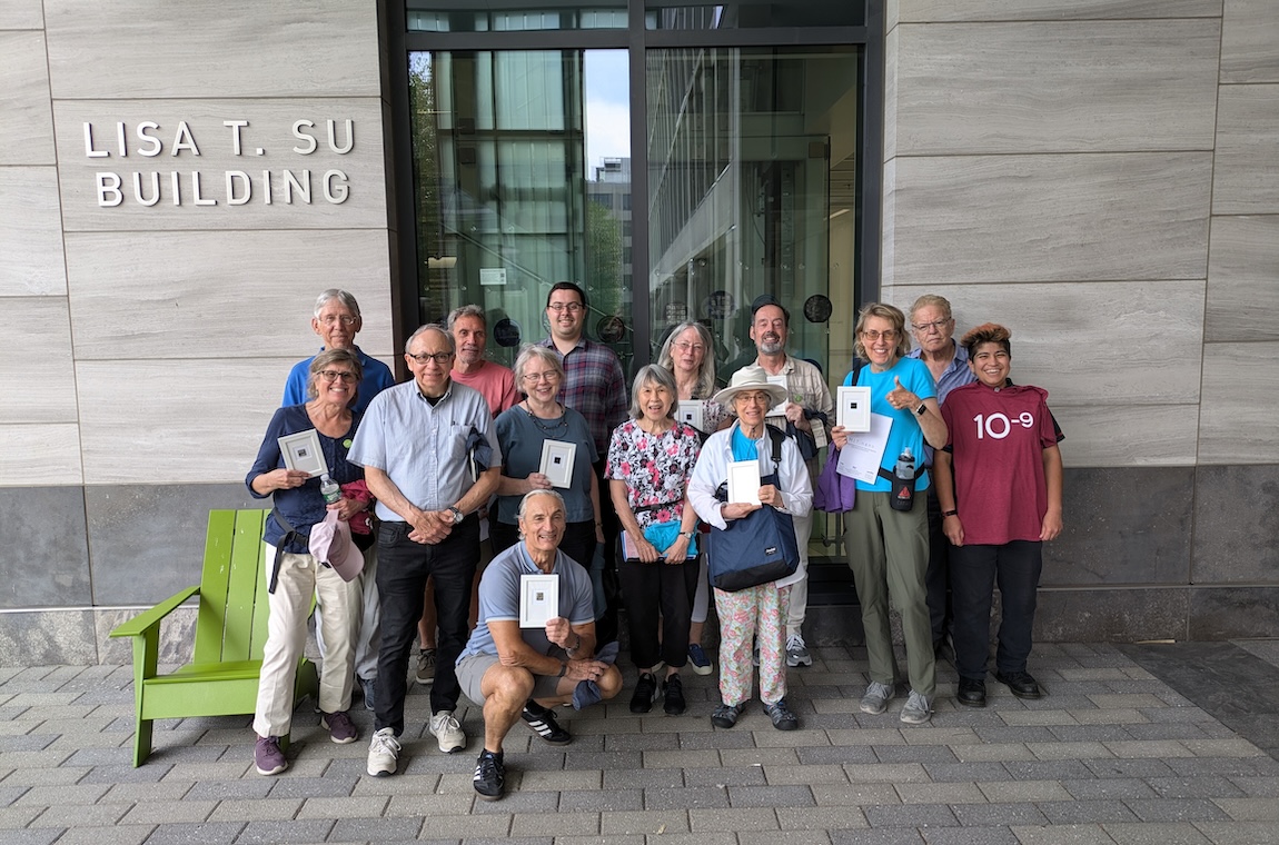 Our retiree group poses with their finished nanoscale wafers in front of the Lisa T. Su nano building.